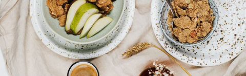 Two bowls of granola and fruit, photographed from above