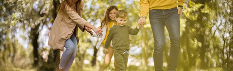 Familie mit Kind spaziert im herbstlichen Park