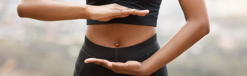 Close-up of a stomach, with the hands forming a circle