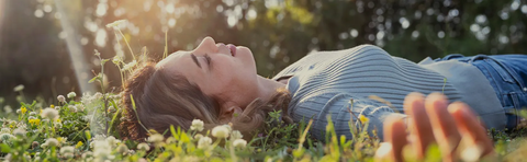 A woman is lying in a flower meadow