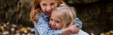 Two children are hugging each other and laughing
