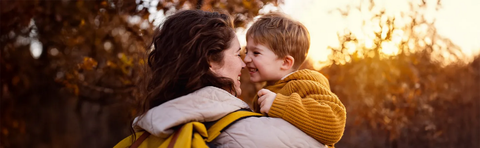 Mutter und Kind schmiegen sich im Herbstlicht aneinander