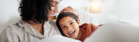 Mutter und Kind kuscheln lachend miteinander