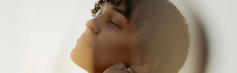A woman is lying in the bathtub with her eyes closed