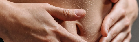 Close-up of two hands on a stomach