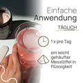 Einfache Anwendung von Pro Kollagen Vegan: 1 × pro Tag ein leicht gehäufter Messlöffel in Flüssigkeit; Hand hält ein Glas mit rosafarbenem Getränk