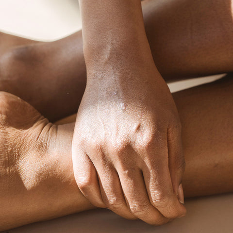 Hand umfasst den Ellenbogen des anderen Arms