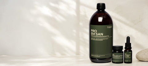 Flasche Pro EM san mit zwei weiteren Produkten des NeuroBiom-Konzepts auf einer hellen Ablage