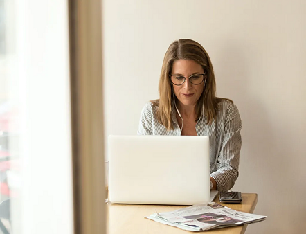 Frau mit Brille arbeitet konzentriert am Laptop