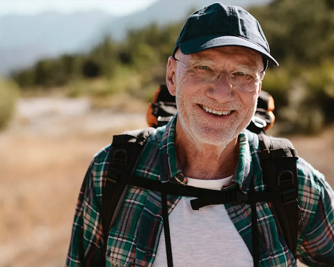 Aktiver älterer Mann beim Wandern in den Bergen – Symbolbild für Herz-Kreislauf-Gesundheit