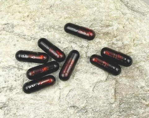 Kapseln mit Astaxanthin auf einem Stein