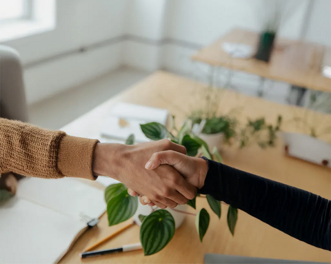 Two people shaking hands across a desk—a symbolic image representing the partnership with TISSO